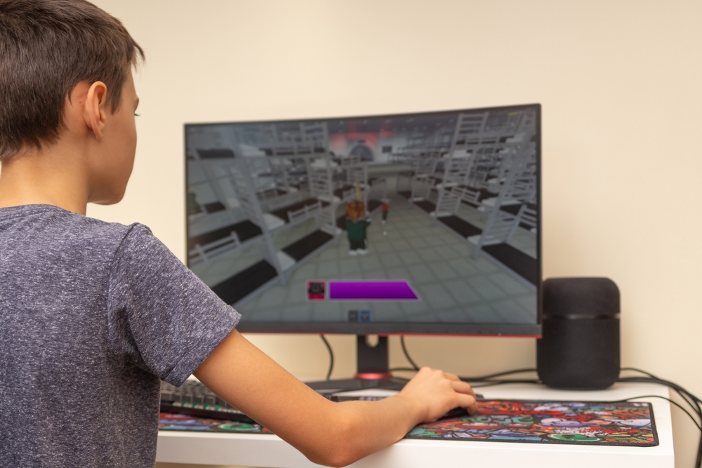 طفل يقوم باللعب على جهاز كمبيوتر - تعبيرية عن خطورة لعبة Roblox 